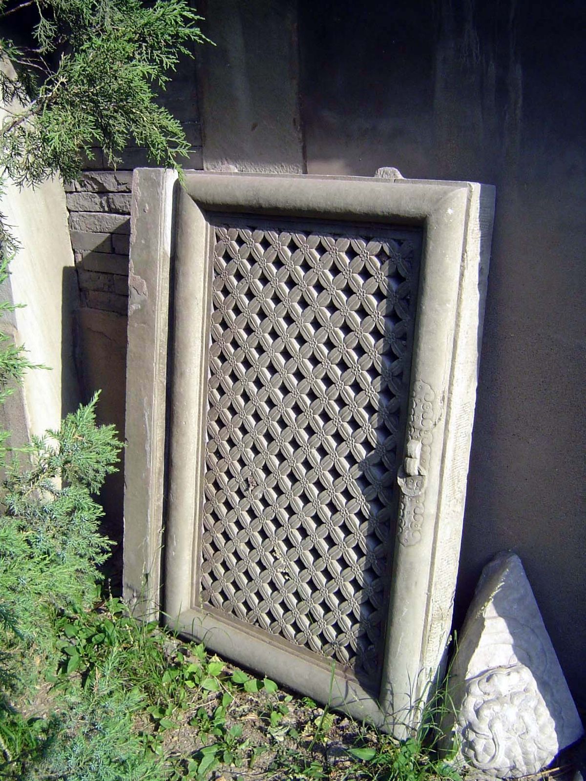 Graveyard bric-a-brac: a lattice screen, with ornamental handle.