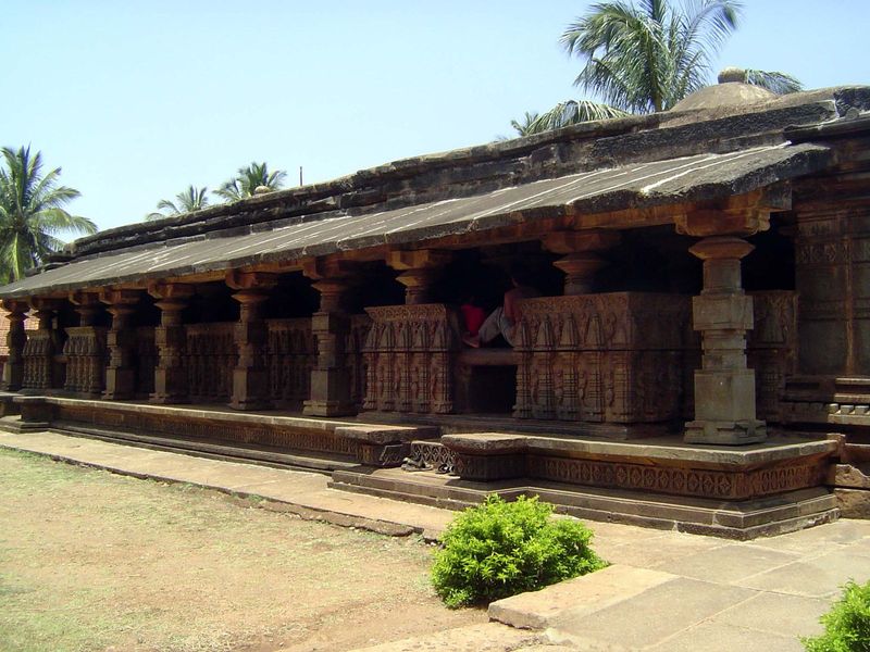 The east side seen from the northeast. The main axis of the temple runs longitudinally, with three shrines on the west side. A boy sits on o