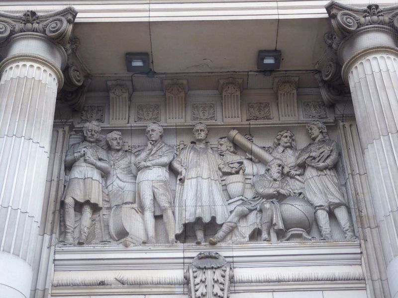 Panels over the entrance represent Art, Science, and Commerce. Presumably this is science, though the question of the moment seems to be "Wh