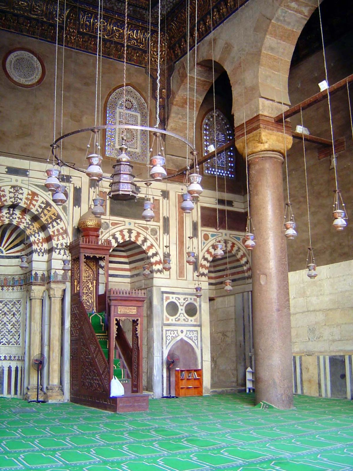 The wooden pulpit, or minbar, is overshadowed by the elaborate ornamentation of the iwan,, which is subdivided by pairs of massive and much 