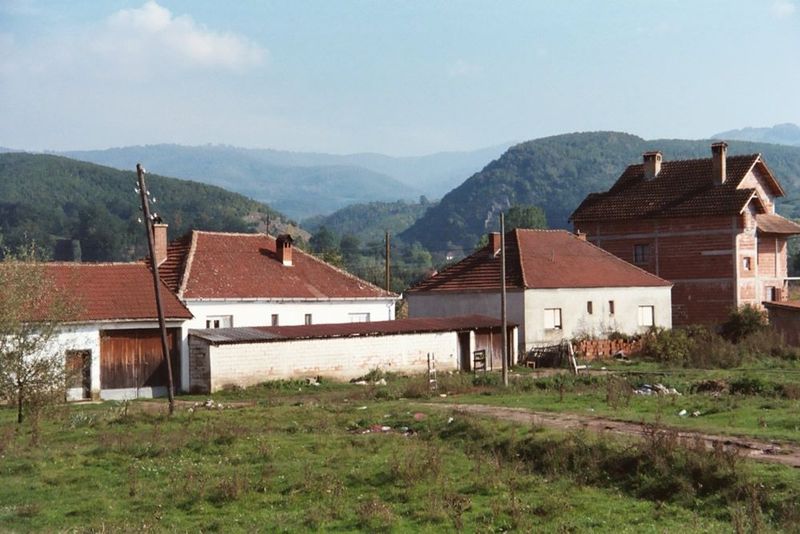 Good-looking farmhouses; uplands of Macedonia in the background.
