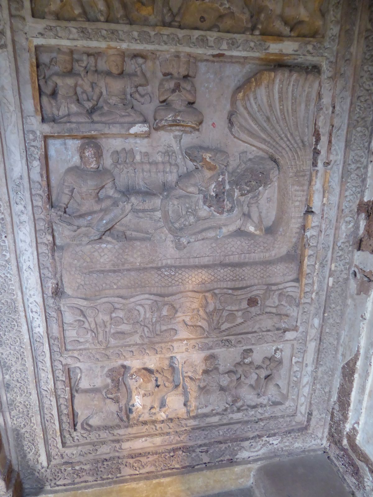 A sheltered panel shows Vishnu asleep on Sesha and dreaming the world's Creation.