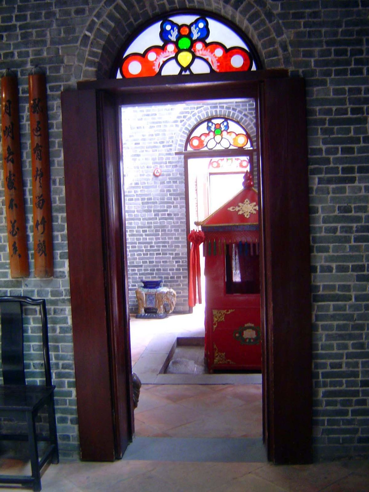 Doorways create a corridor through the rooms, in this case bending around a bright sedan chair.