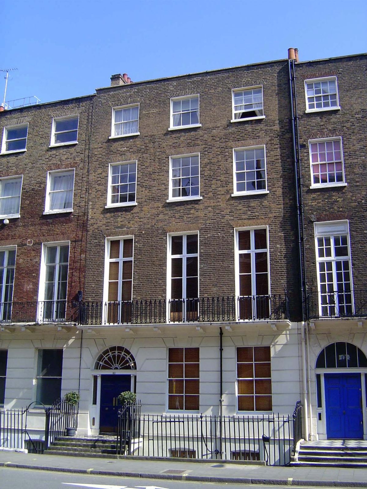 Here there are only a few grudging concessions to appearance: simulated rusticated stone, a fanlight, a bit of color on the door. Perhaps so