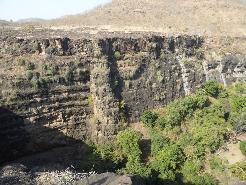 A dozen or more lava flows are stacked up. At the far right you can make out Caves 28, 27, and the taller 26, with an arched window over the