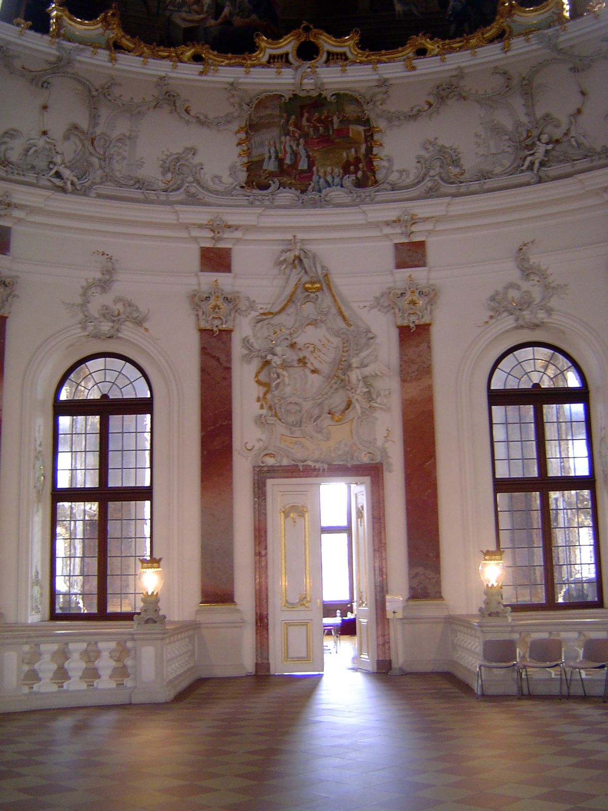 The platform atop the staircase leads into rooms on either side. Keep an eye on the plasterwork over the door.