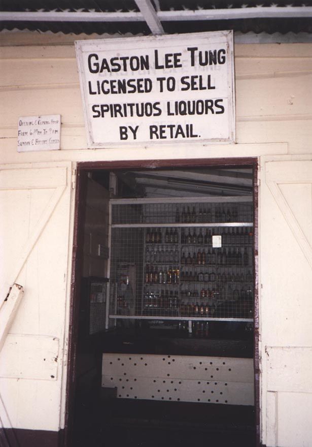 A Toco merchant, selling from behind heavy screens above the counter.