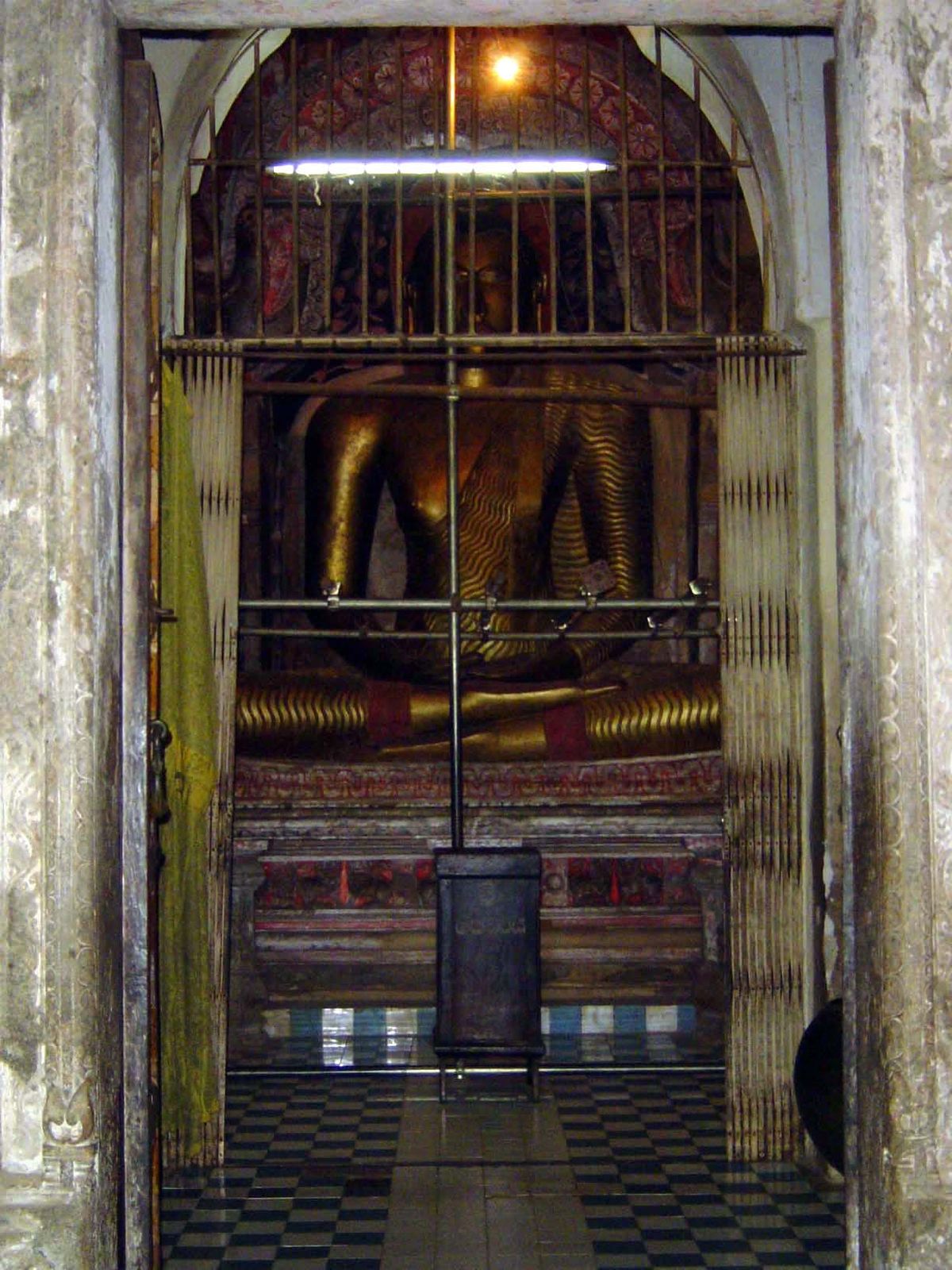Inside, the temple has been wretchedly improved with fluorescent tubing, an accordion gate, and tile flooring.