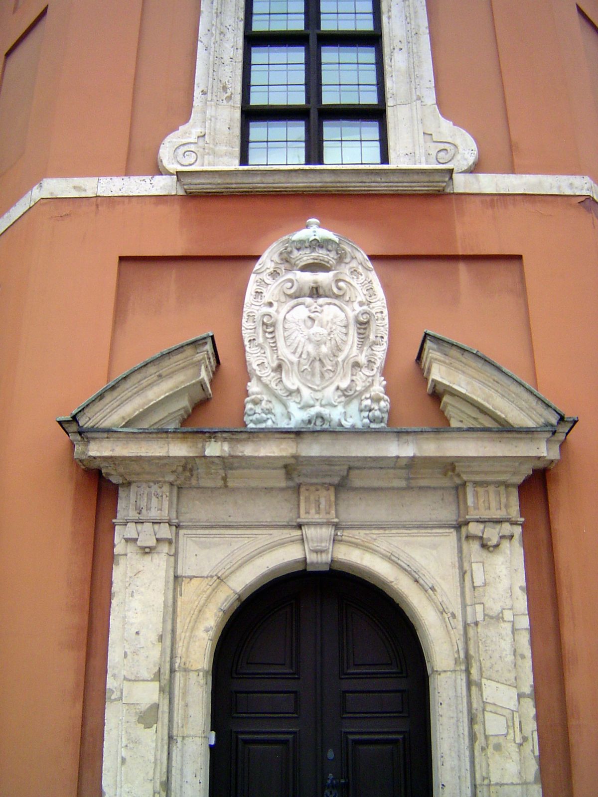 The Polish coat of arms: a white eagle with golden crown, all mounted on a shield.