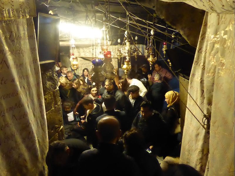The crowd here in the so-called Birth Cave is trying to see Christ's manger. Anything flammable from long ago was lost in a fire in 1869. St