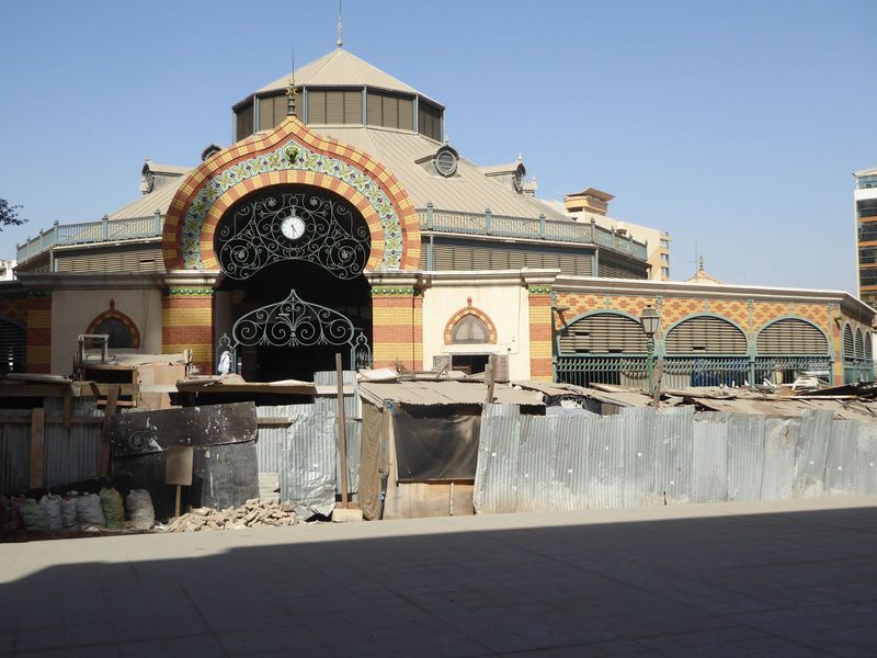 The mask-covered wall is part of the Kermel Market, the original European public market. This is a copy, built in 1997 after the original bu