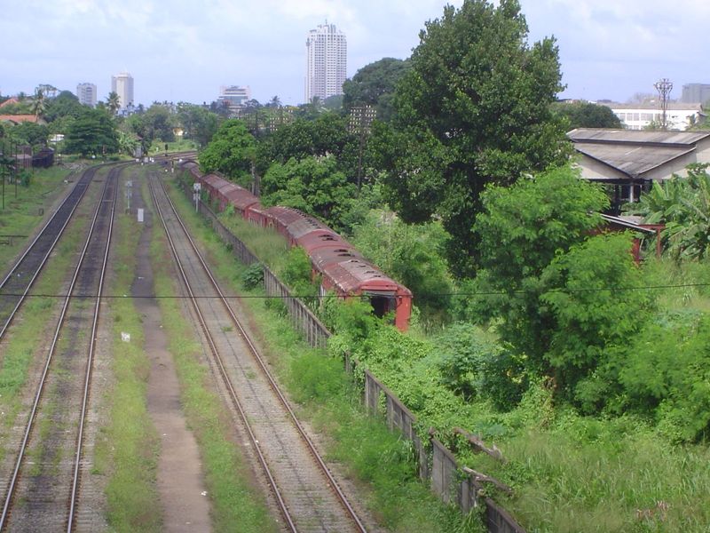 The busy mainline from the interior into the city; on the right, a train running late.