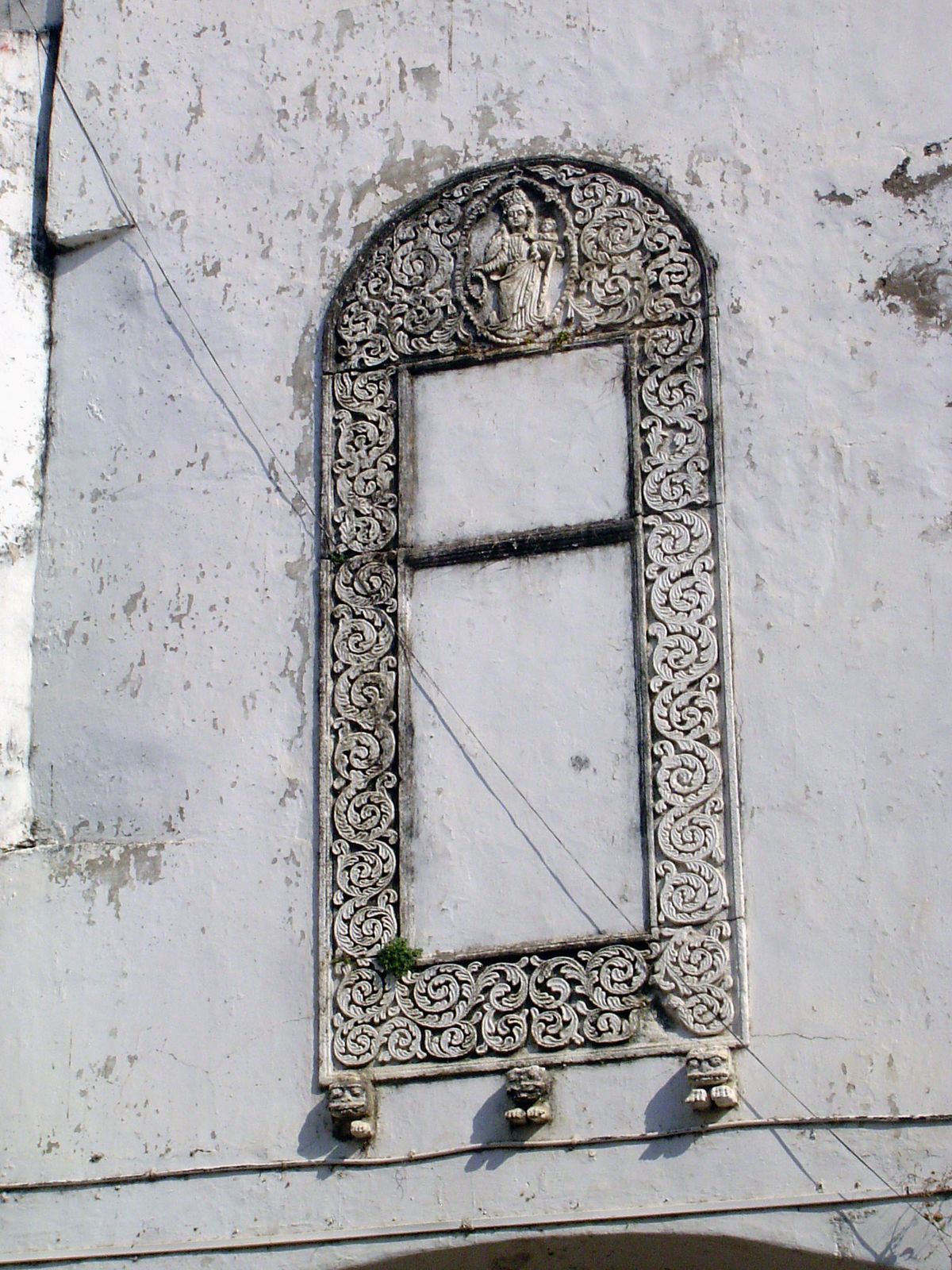 Another virgin and child in a floral frame supported by three lion brackets.
