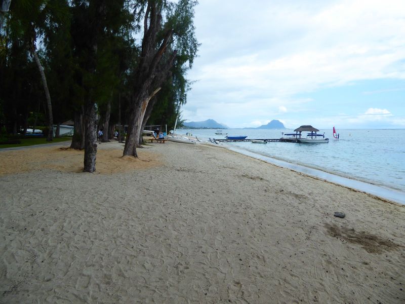 But sand and sea are everything for vacationers. That's Le Morne in the distance. The white-topped wall down the beach marks the boundary of