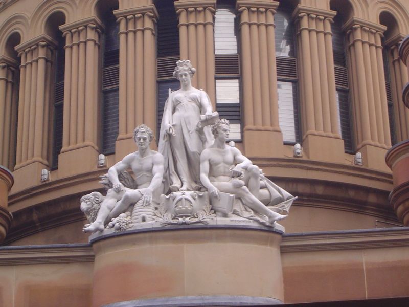 The Guardian Genius of the City holds the symbols of wisdom and justice. To her left, Labor and Industry has wheat under one elbow, a ram at