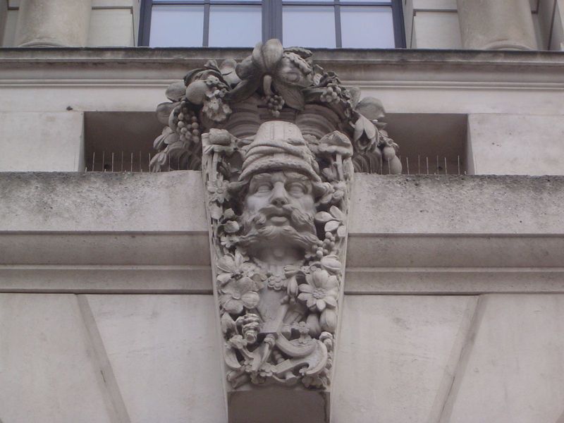 Eric Raymond Broadbent added several smaller figures above the building's arched entrances. Here, presumably from the flowerpot hat, a Persi