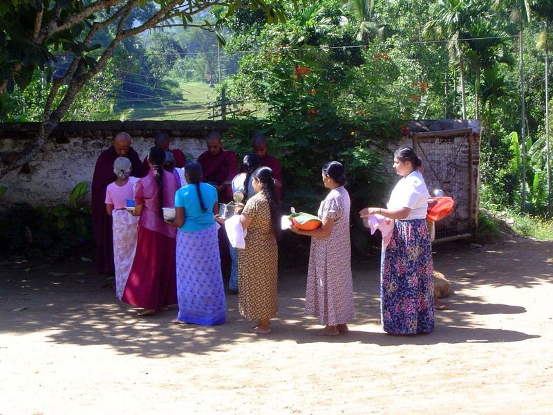 Village women bring food to the monks who come by weekly.