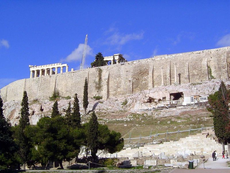 The Parthenon rises above the south wall, with the Theater of Dionysus below. The two columns that appear embedded in the wall—the Wall of C