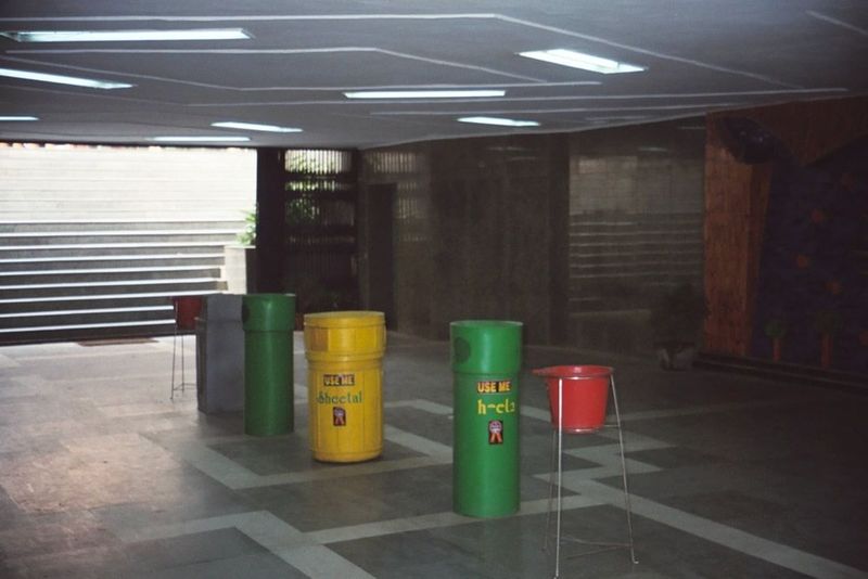Early morning in a New Delhi pedestrian underpass, with waste baskets arrayed as lane dividers.