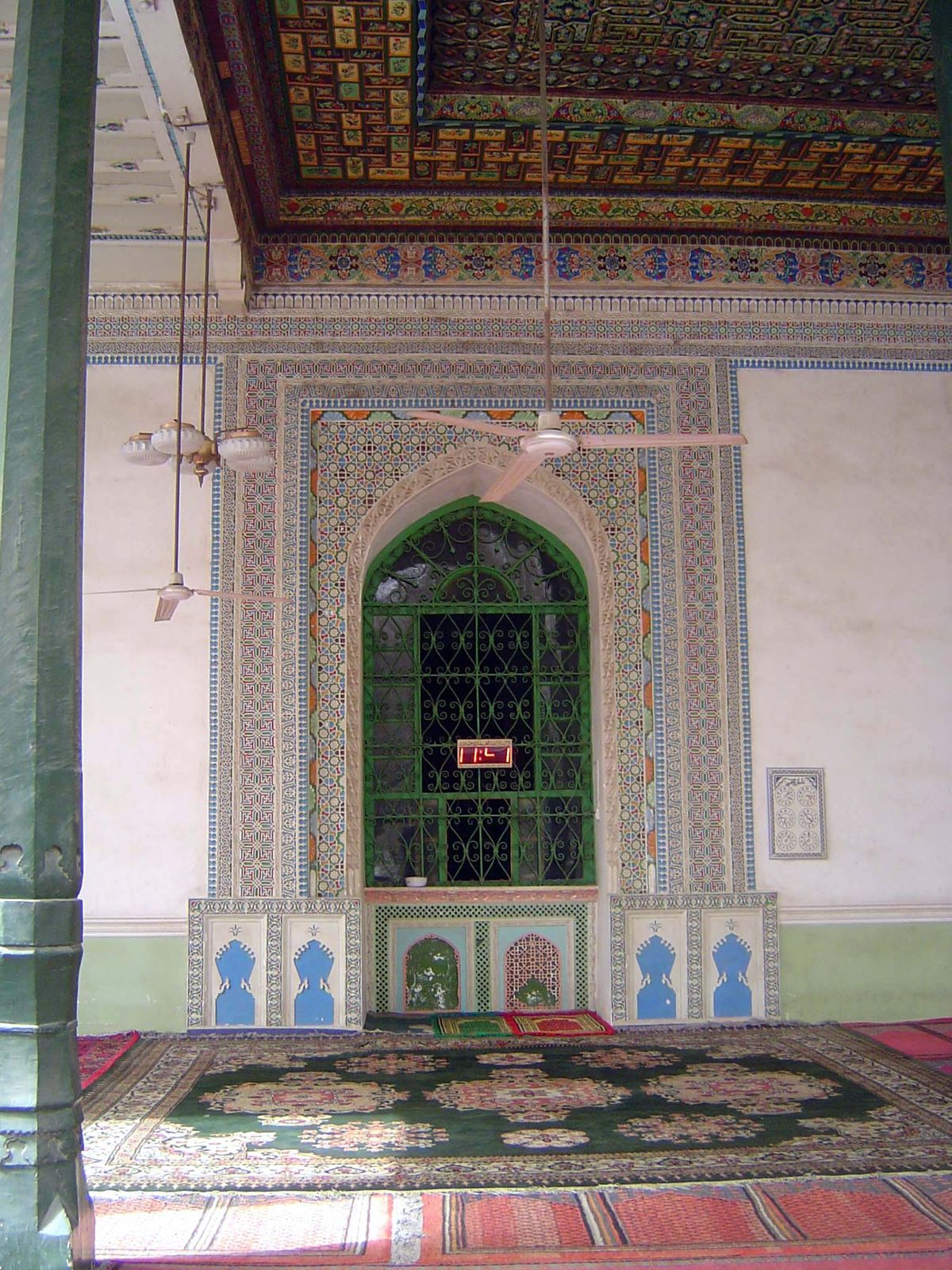 The Mecca-facing mihrab, under a coffered ceiling.