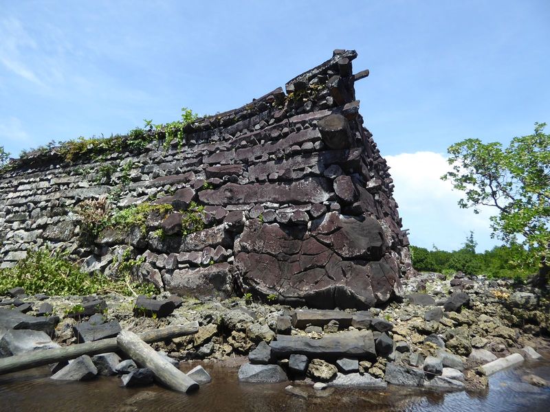 The path makes its way around the southeast corner of the enclosure. We're stepped into the water to get a good look at the wall. The corner