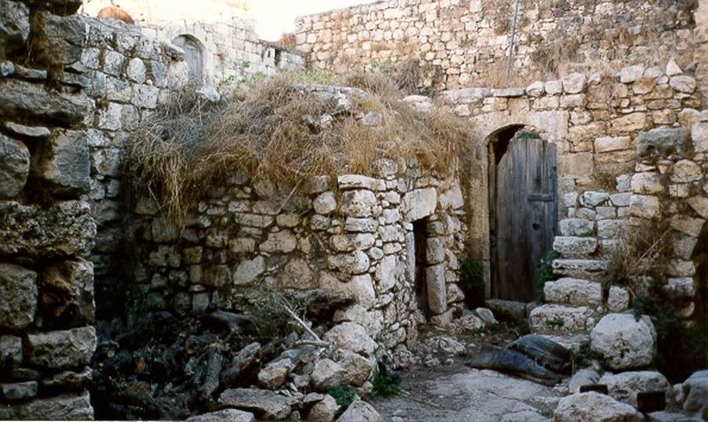 A primitive house in need of repair but with unusual lintels, rather than arches, over the doors.