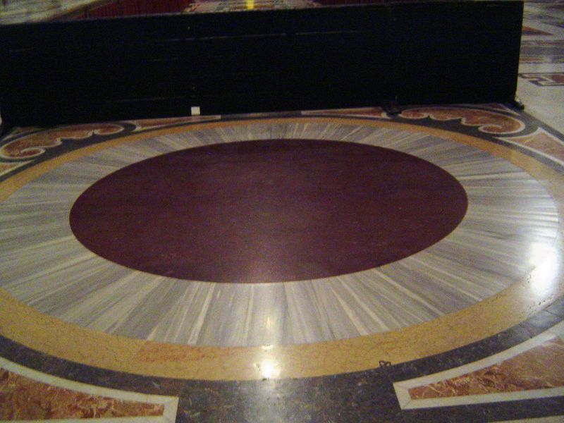 Set in the floor and easy to overlook is this rota or wheel, perhaps a disc cut from a porphyry column. It is a remnant of the four "wheels"