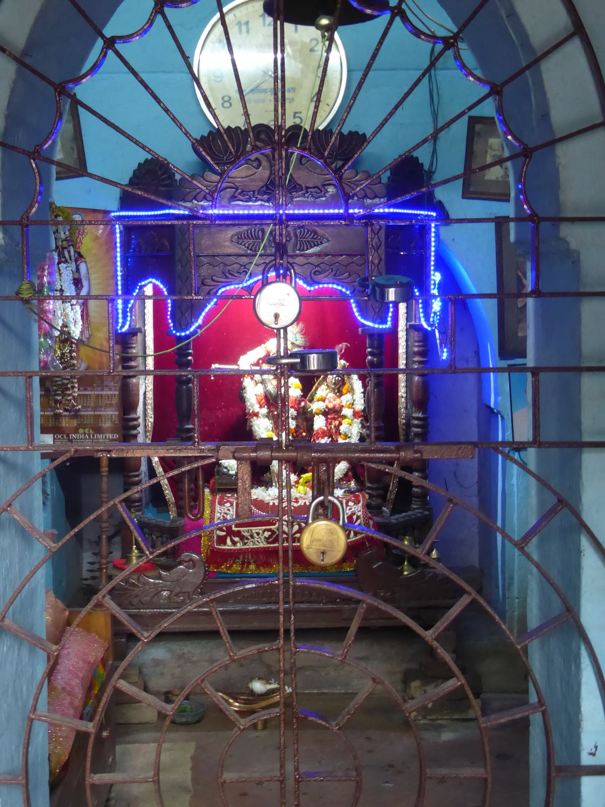 The shrine holds images of Krishna and Radha draped in flowers. Too bad we can't see him clearly, but you can see his flute, never far away.