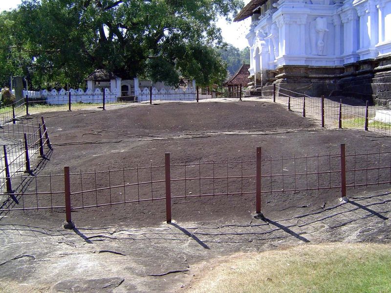 On the south side of the temple, a fenced area protects an inscription.