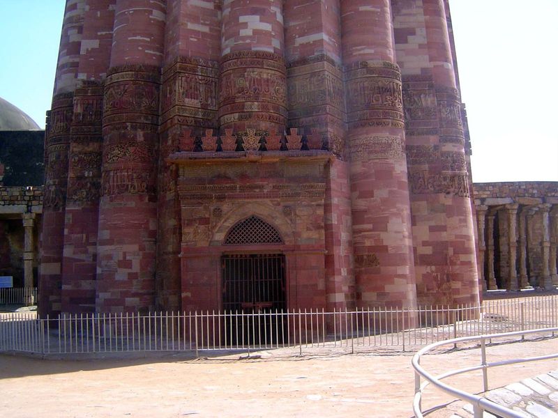 Despite the flutings, the tower, made of red sandstone, is approximately circular. The gate, leading to interior stairs, has been closed sin