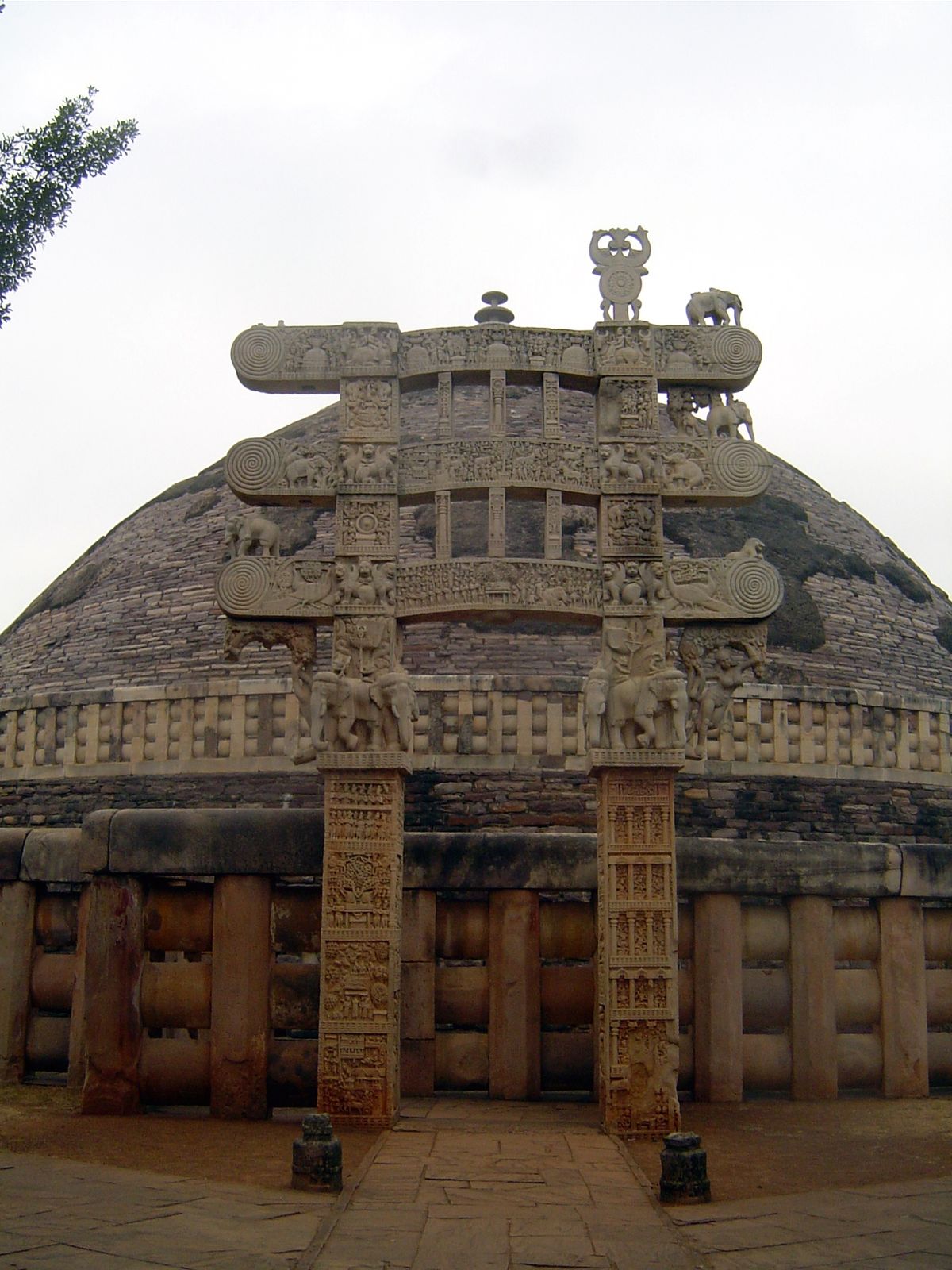 Approaching the eastern gateway. The upper architrave again shows the last seven Buddhas of this eon; the middle one shows the Buddha's depa