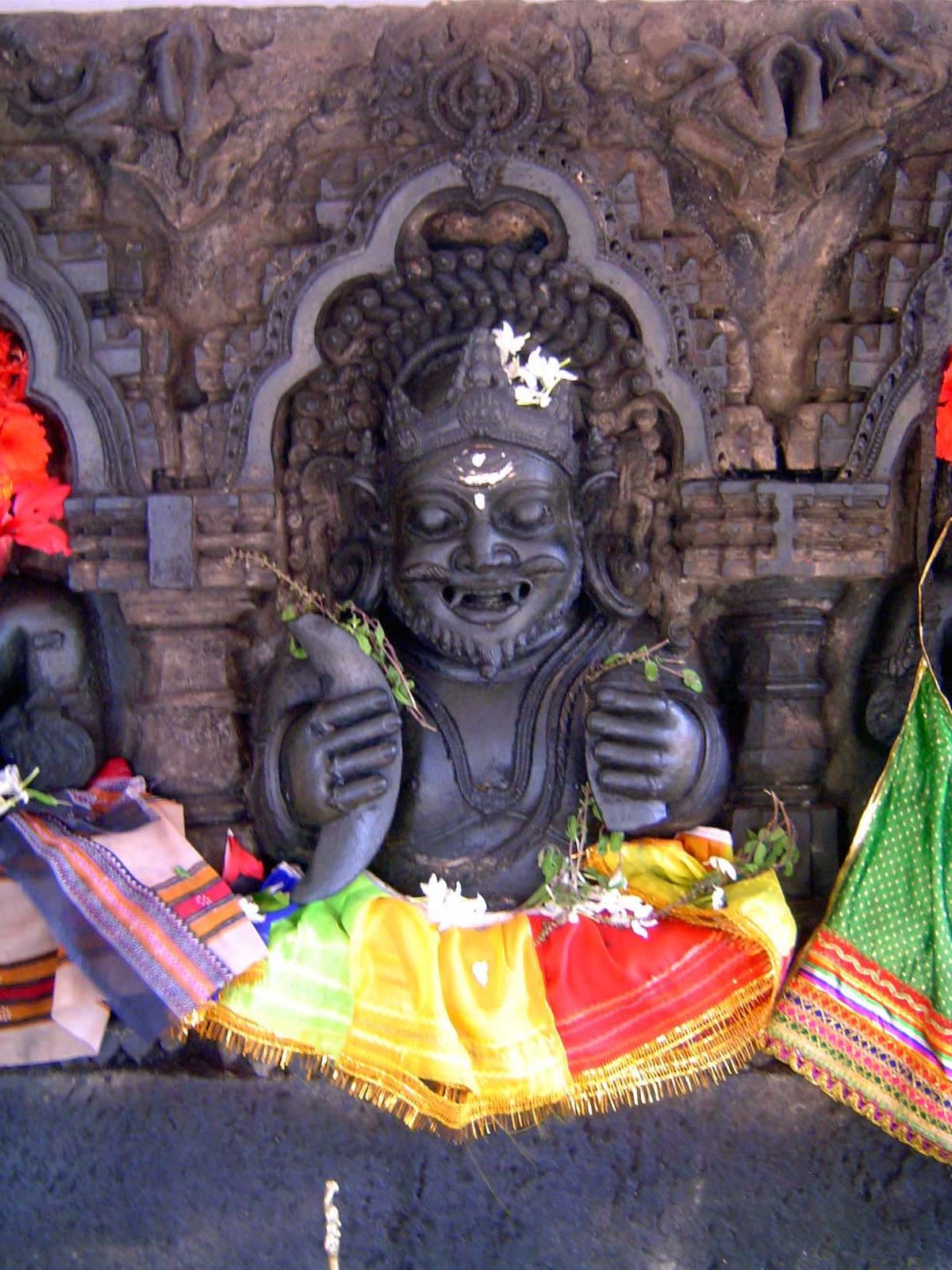 Rahu. He carries crescents because he is associated with lunar eclipses.