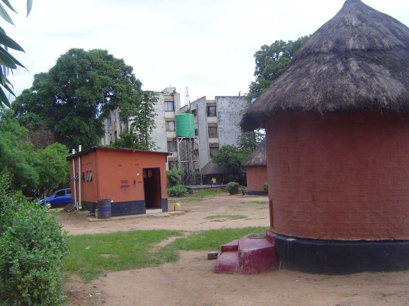 Latrines for the huts; in the background, apartment blocks to house the successor to the Northern Rhodesia Regiment.