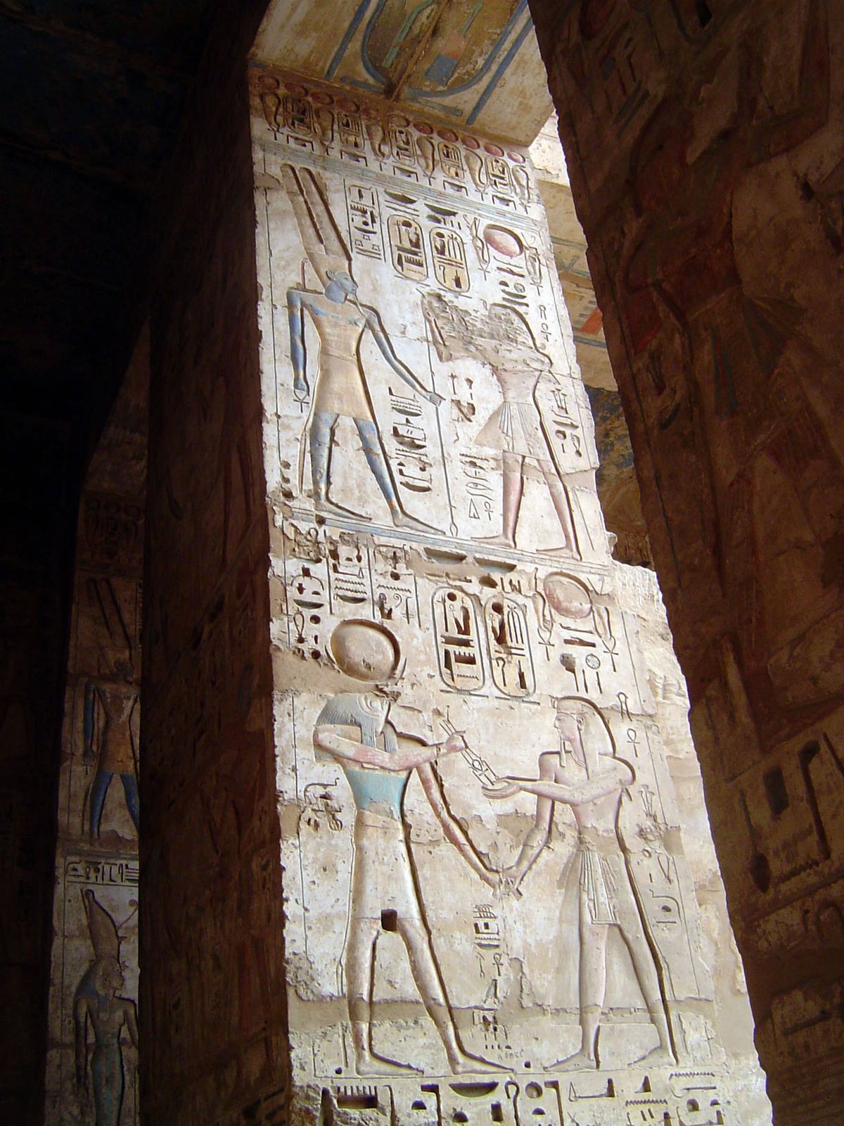 The king makes an offering to Khonsu, indicated by the solar disc and crescent moon under it.