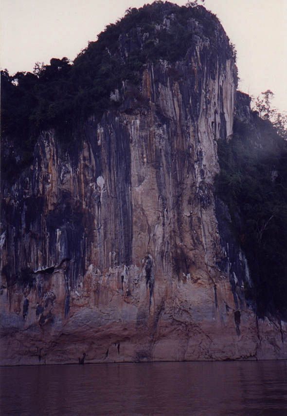 The Tham Ting Buddha caves are set into a cliff around which the Mekong curves some 15 miles upstream from Luang Prabang.