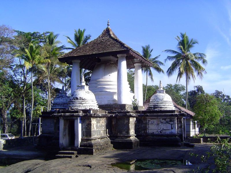 A stupa at the entrance is overshadowed by a massive and ungainly Kandyan roof.