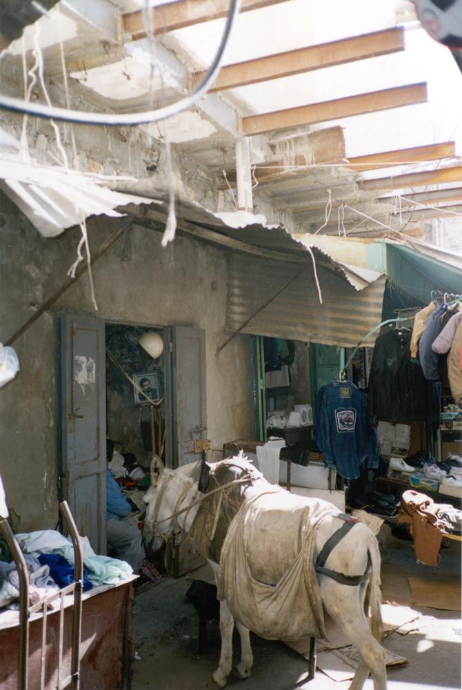 Much of the market or suq is architecturally rough, especially at points like this one, where Jewish settlements overhang Palestinian shops.
