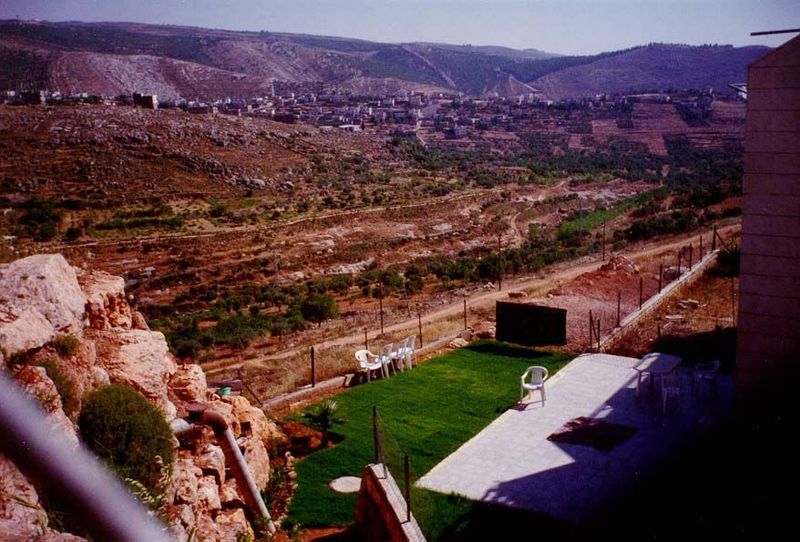 A lawn behind a home in Betar Illit. In the distance is Nahalin, at the foot of the Judean Plateau. The pine forests on the distant slopes a
