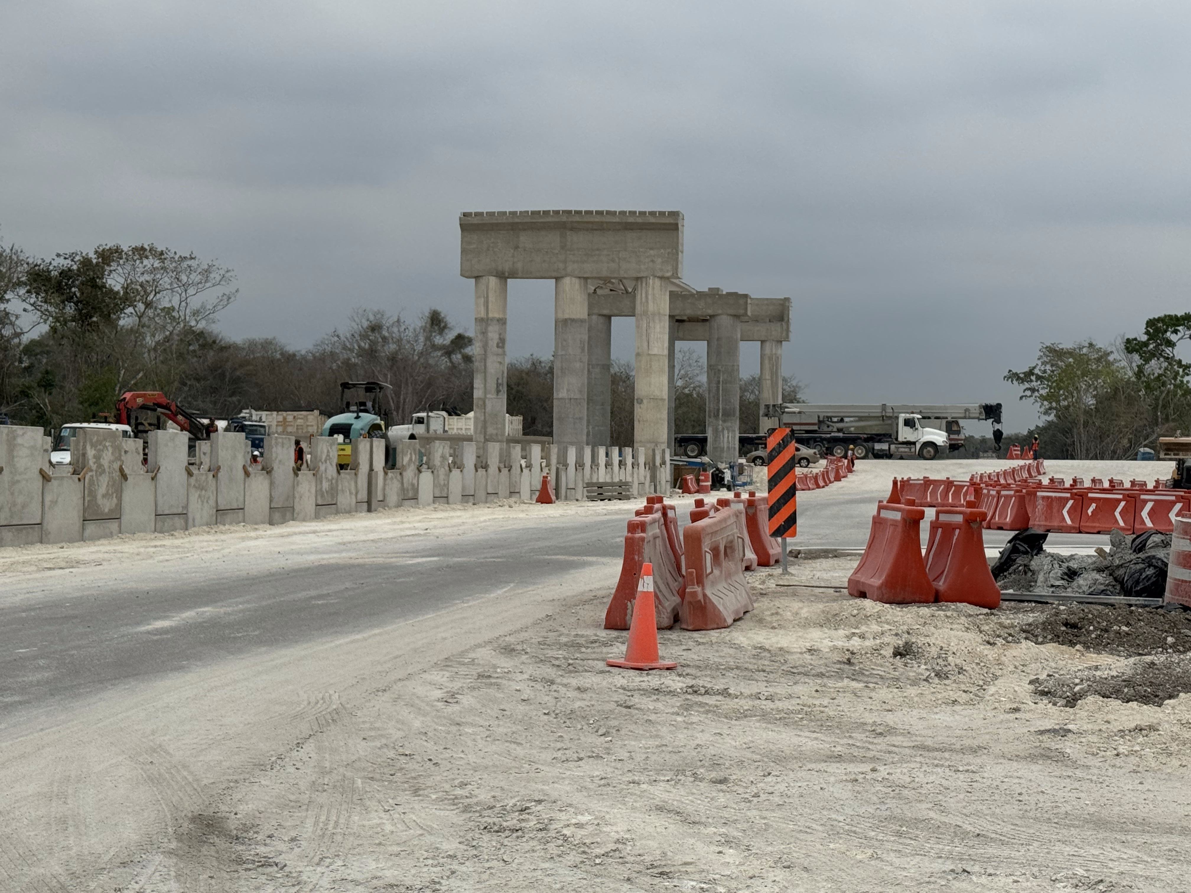 The road will use this overpass to clear the train line, which crosses where that truck is.