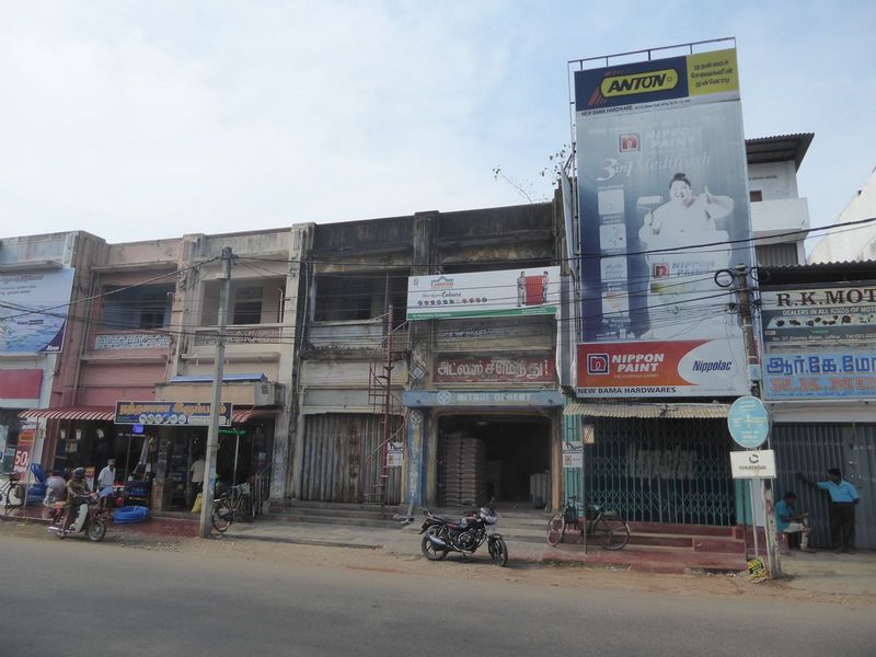 Ten years of peace, yet buildings on a main street have yet to be repaired. The sacks of cement hint that someone somewhere is building some