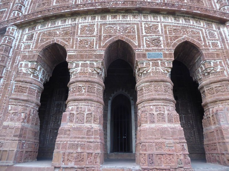 The main entrance is on the south; the opposite face has a blind entrance.  Krishna plays a flute on the right, while Balarama blows a horn 
