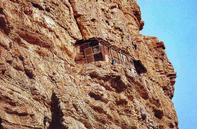 Monastic cells are tucked into crevices along the cliff; some seem almost inaccessible.