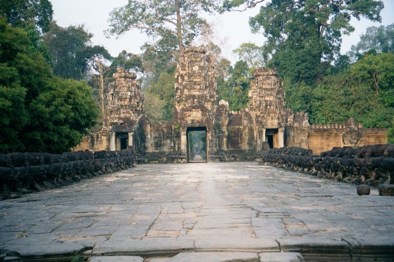 A naga bridge, like those leading to Angkor Wat and Angkor Thom, leads to Preah Khan's eastern gate or gopura. The demons on the right and g