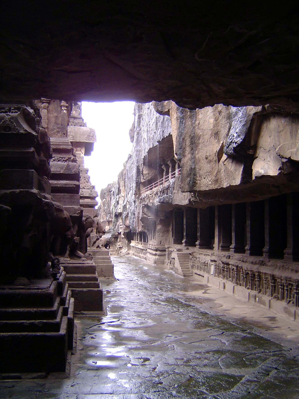 Looking back toward the entrance. Rainwater is running off the edge of the surrounding cliffs.