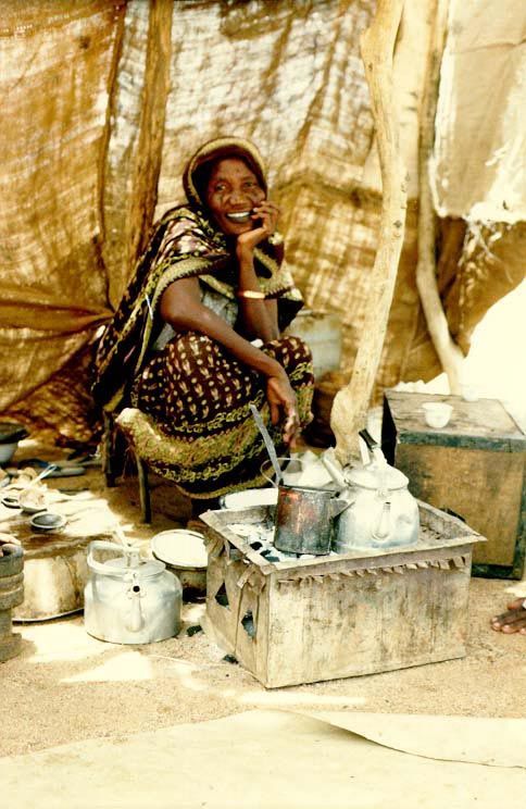 A woman boils tea and waits for customers.