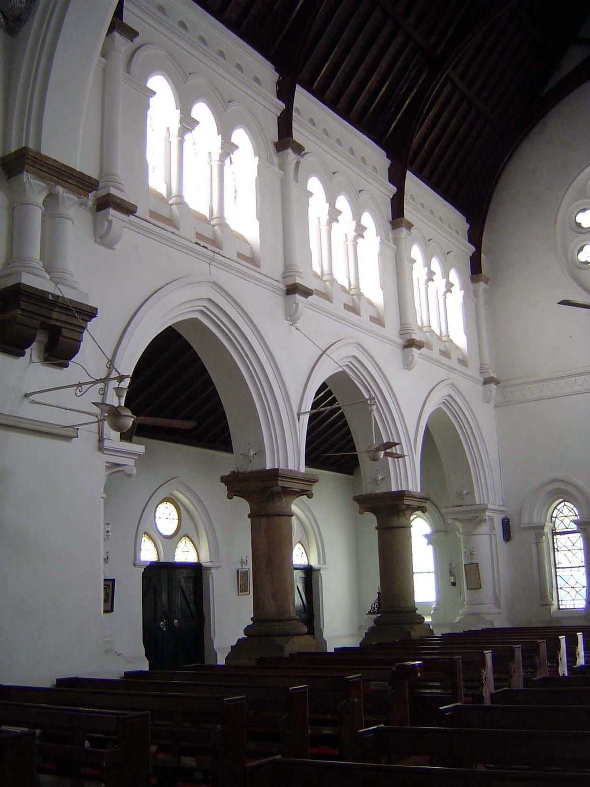 The stone columns are awkwardly juxtaposed against the brilliantly white plastered brick.