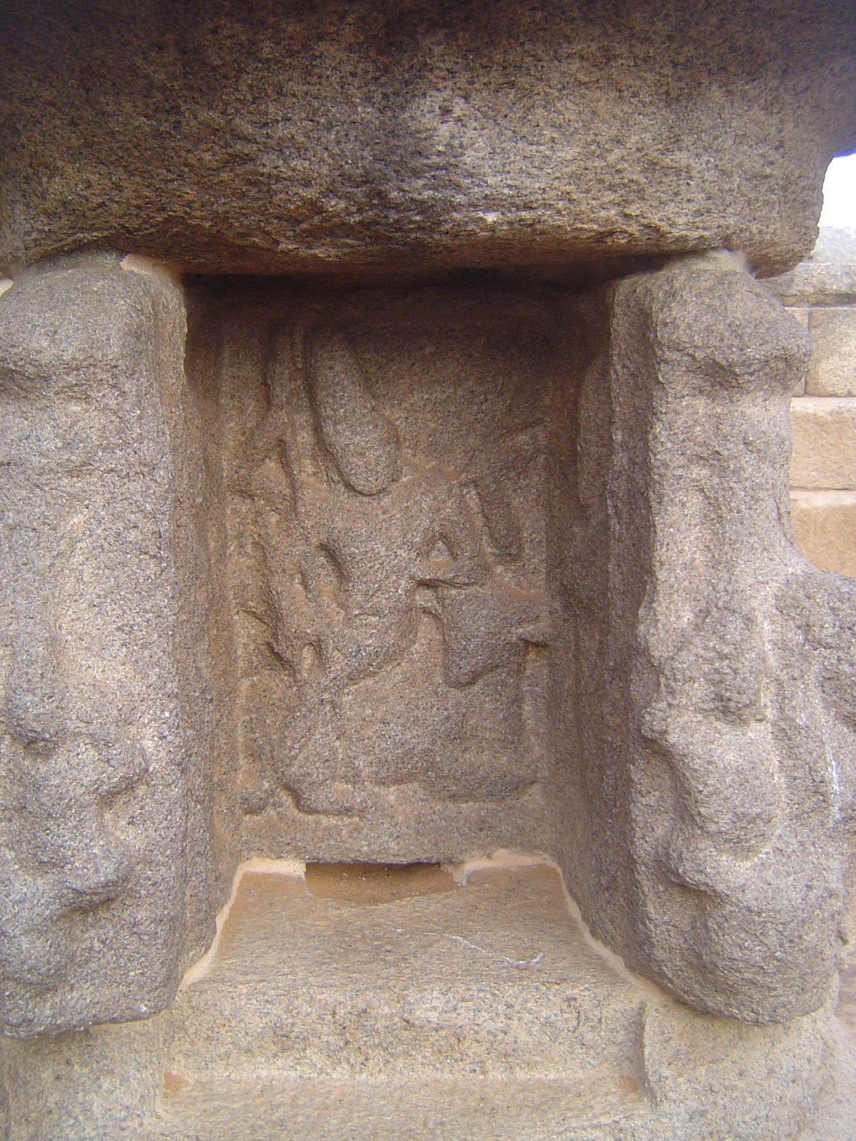 It's Durga, sitting on the Buffalo Demon whom she beheads. The niche presumably held a lamp.
