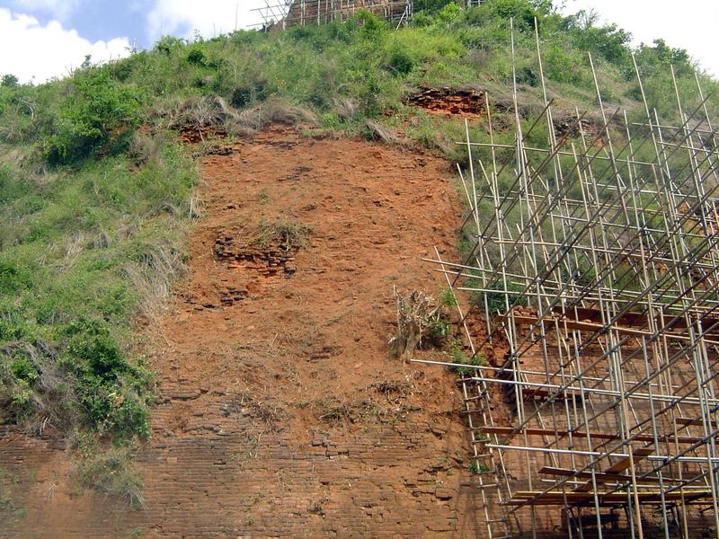 Unprotected by plaster, the brick weathers into rubble.