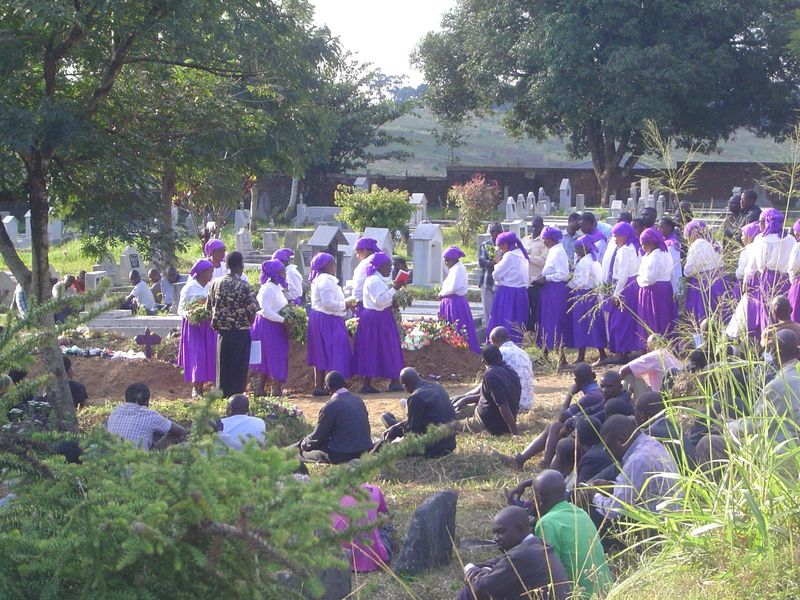Singing hymns while circling the grave.