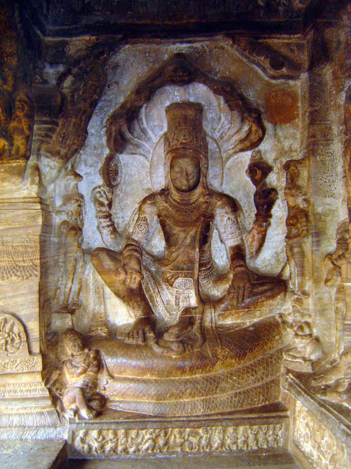 Vishnu seated in the maharajalila posture of Buddhist iconography on the great serpent Adisesha, whose five heads flare behind him as an umb